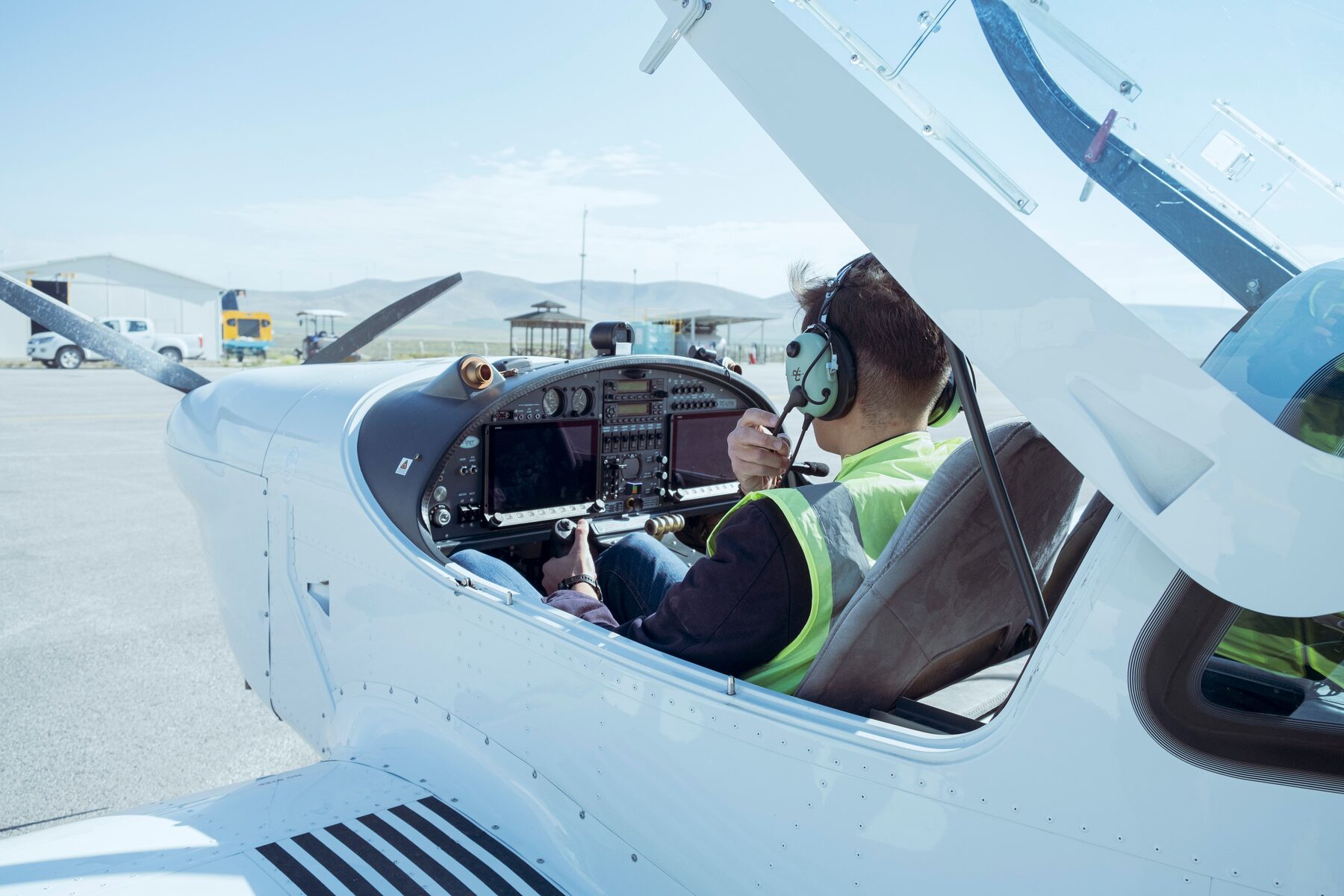 Pilote au micro dans le cockpit d'un avion léger, en contact radio avant le décollage